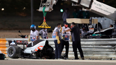 Los oficiales de pista retiran partes del automóvil del lugar del accidente del piloto francés, Romain Grosjean, del equipo Haas el domingo 29 de noviembre de 2020.