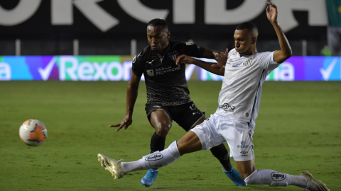 El jugador Lucas Braga (d) de Santos disputa un balón con Pedro Perlaza de LDU hoy, en un partido de los octavos de final de la Copa Libertadores entre Santos y LDU de Quito, el 1 de diciembre de 2020.