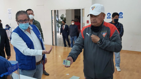 Un ciudadano se retira la mascarilla para verificar su identidad en el simulacro de las elecciones, realizado el 15 de noviembre de 2020 en Quito.