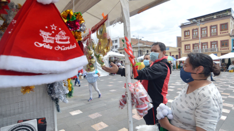 Personas en un quiosco de venta de objetos navideños en Cuenca, el 11 de diciembre de 2020. 