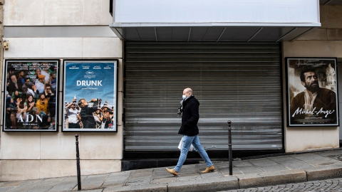 Un peatón camina junto a una sala de cine cerrada en París, Francia, el 7 de enero de 2021. 