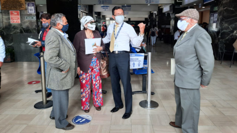 Un grupo de jubilados conversa con un funcionario IESS, en Quito, el 20 de enero de 2021.