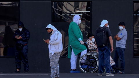 Personal sanitario y familiares de pacientes esperan afuera del hospital IESS del Sur, en Quito.