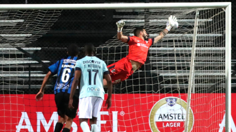 Los jugadores de Liverpool y Católica ven al arquero Hernán Galíndez intentar atajar el remate de Fabian Dávila, que anotó de tiro libre el 1-1 en la ida de la fase uno de la Libertadores 2021.