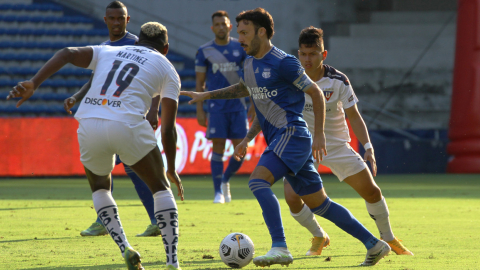 Los jugadores de Emelec y Liga de Quito disputan un balón en la Fecha 7 de la LigaPro 2021. 