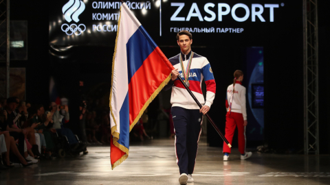 Una modelo camina por la pasarela con la bandera rusa durante la presentación de los uniformes oficiales que usarán los deportistas rusos y que fueron diseñados por Zasport para los Juegos Olímpicos de Tokio, el 14 de abril de 2021. 