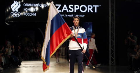 Una modelo camina por la pasarela con la bandera rusa durante la presentación de los uniformes oficiales de la delegación.