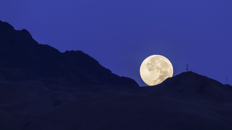 Vista de la luna rosada, asociada con el inicio de la primavera, captada el 26 de mayo cuando se ocultaba por el volcán Atacazo, ubicado al suroeste de Quito.