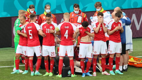 Los jugadores de la selección de Dinamarca cubren al jugador Christian Eriksen luego de su desvanecimiento en la cancha.