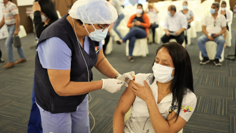 Una persona del Ministerio de Salud le aplica la primera dosis de la vacuna contra el Covid-19 a la luchadora Lucía Yépez, en Guayaquil, el 2 de junio de 2021.