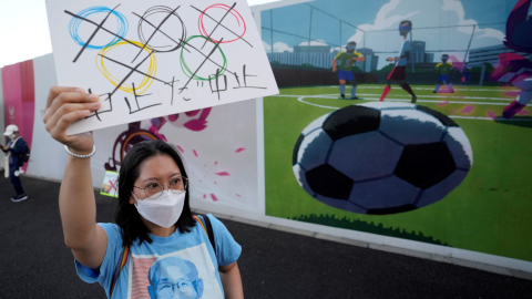 Una mujer levanta un cartel en una protesta en contra de la realización de los Juegos Olímpicos, en Tokio, el 16 de julio de 2021.