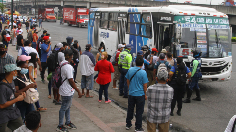 Personas se aglomeran en una para de buses en Guayaquil, el 15 de julio de 2021.