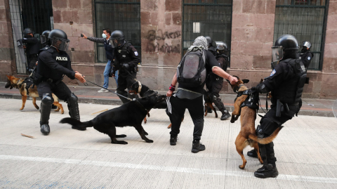 Policías con canes se enfrentan con manifestantes durante la protesta del 11 de agosto de 2021, en Quito.