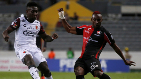 Julián Quiñones (d) de Atlas disputa el balón con Erick Castillo de Xolos, este jueves 28 de octubre de 2021 durante un partido de la jornada 16 del Torneo Apertura 2021 del fútbol mexicano disputado en el Estadio Jalisco en Guadalajara.