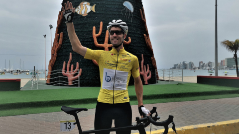 Jean Lachance levanta su brazo y posa con la camiseta de líder de la Vuelta al Ecuador, el 9 de diciembre de 2021.