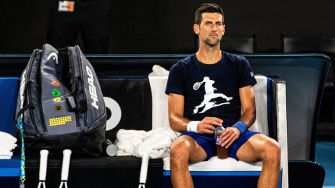 El tenista serbio Novak Djokovic descansa durante un entrenamiento para participar en el Abierto de Australia en el Melbourne Park, el viernes 14 de enero de 2022.