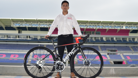 Diego Puetate posa con la bicicleta BMC que usarán los ciclistas del Team Banco Guayaquil durante la temporada 2022. 