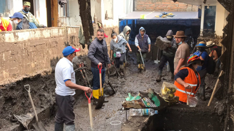 Varios voluntarios en las tareas de limpieza de calles de La Comuna, tras el aluvión, en Quito. Imagen del 2 de febrero de 2022.