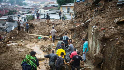 Hombres transportan un cuerpo en un deslizamiento de lodo en Morro da Oficina, tras las inundaciones en Petrópolis, Brasil, del 16 de febrero de 2022.