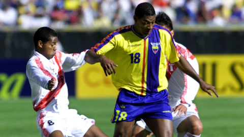 Eduardo Hurtado maneja una pelota contra dos rivales peruanos, en Quito, el 29 de junio de 2022.