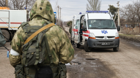 Una ambulancia pasa junto a un soldado en un campamento de refugiados de Mariúpol, Ucrania, el 5 de marzo de 2022.