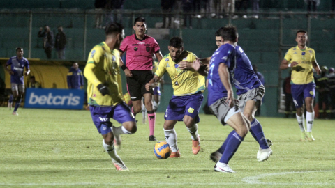 Los jugadores de Gualaceo  manejan una pelota ante los futbolistas de Emelec, en Azogues, el 13 de marzo de 2022.