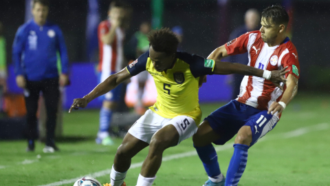 Romario Ibarra, de Ecuador, defiende una pelota ante Ángel Romero, de Paraguay en Ciudad del Este, el 24 de marzo de 2022.