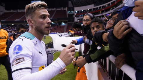 Ezequiel Piovi firma autógrafos después del partido de Liga ante Antofagasta, en el estadio Rodrigo Paz Delgado, el 12 de abril de 2022.