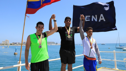 David Farinango levanta sus brazos en el podio del Campeonato Nacional de aguas abiertas, en Salinas, el 22 de abril de 2022.