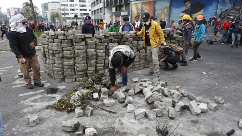 Manifestantes sacan parte del pavimento para armar una barricada, en una de las calles cercanas a la Casa de la Cultura, el 24 de junio de 2022. 