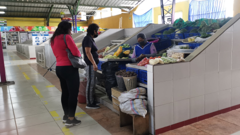 Dos personas hacen compras en el mercado de Conocoto, en el suroriente de Quito, el 29 de junio de 2022.