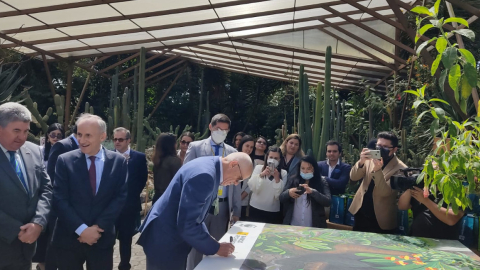 Antonio Acosta, presidente de Banco Pichincha, firma un cuadro durante la presentación del programa Suscríbete al Planeta.