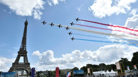 Aviones, cercanos a la Torre Eiffel, pintan la bandera francesa en el cielo de París. 