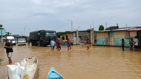 Personas caminan por un sector de Balao, cantón de Guayas, en las inundaciones de febrero de 2022. 