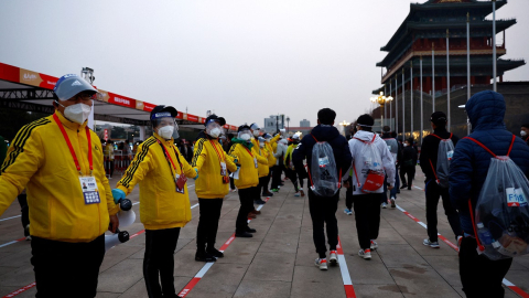 Voluntarios resguardan la entrada de la plaza de Tiananmen, en Beijing, China, durante la maratón, 6 de noviembre de 2022. 