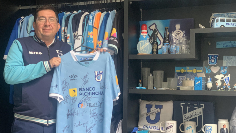 Carlos León posa con una camiseta de la Universidad Católica y de fondo aparece su colección.