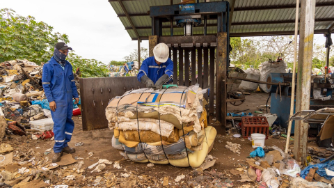 Dos trabajadores en Santa Cruz, Galápagos, durante el reciclaje de colchones. 