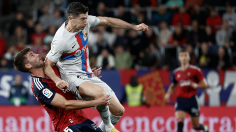 El delantero del FC Barcelona Robert Lewandowski golpea a David García, de Osasuna.