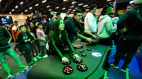 Jóvenes frente a una consola gigante de Xbox 360 en una feria 'geek' de Bogotá, Colombia, el 17 de octubre de 2022. 