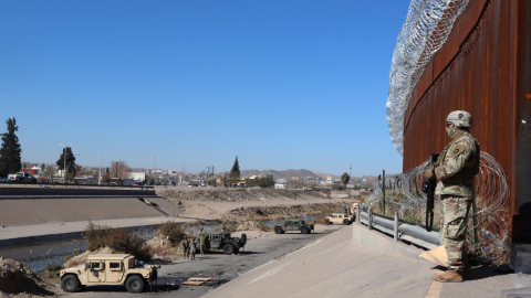 Un integrante de la Guardia Nacional estadounidense vigila el paso de migrantes por la valla fronteriza de El Paso, Texas, frente a Ciudad Juárez, México, el 21 de diciembre de 2022.