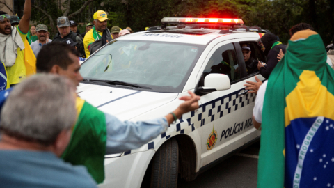 Partidarios del expresidente Jair Bolsonaro bloquean un coche de policía durante las protestas en Brasilia, Brasil, el 8 de enero de 2023.