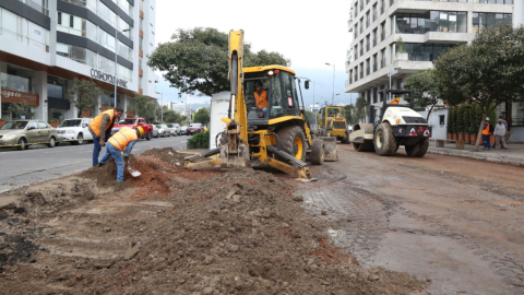 Maquinaria y trabajadores de la Epmmop repavimentan la calle Portugal, en el norte de Quito, el 13 de enero de 2023.