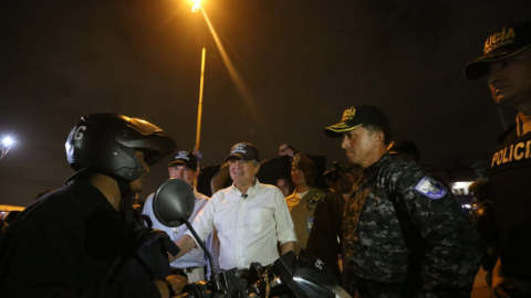 El presidente Guillermo Lasso (centro), junto a policías en la Entrada de la 8, en Guayaquil, 15 de febrero de 2023. 