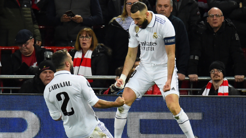 Karim Benzema del Real Madrid celebra con su compañero Dani Carvajal tras marcarle al Liverpool en la Champions League, el 21 de febrero de 2023.