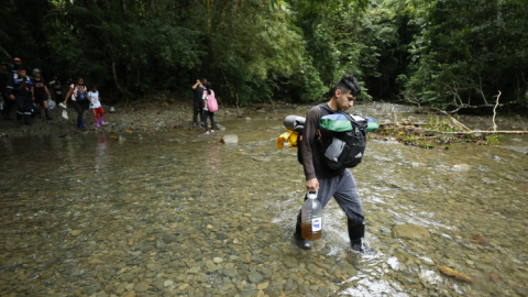 Migrantes cruzan un río en el Tapón del Darién, una de las selvas más peligrosas del mundo rumbo al llamado "sueño americano". Panamá, octubre de 2022.