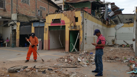 Obreros limpian el exterior de una casa colapsada tras el terremoto en las calles Boyacá y Páez, en el centro de Machala. 