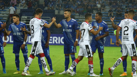 Los jugadores de Emelec y Deportivo Cuenca se saludan antes de un partido por la Copa Sudamericana, en Guayaquil, el 9 de marzo de 2023.