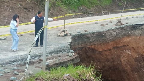 Personas contemplan el hundimiento en Pallatanga, en la vía Riobamba - Guayaquil.