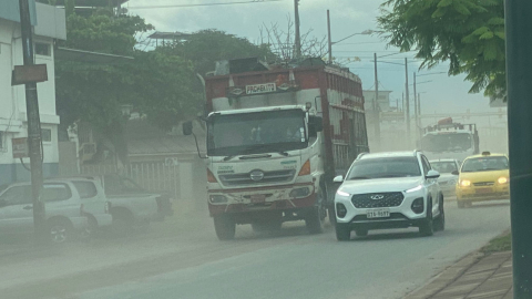 Vehículos transitan por una vía cubierta por ceniza del Sangay, en Babahoyo, Los Ríos, el 21 de abril de 2023. 