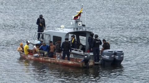 Miembros de la Armada solicitan documentos de identidad a los ocupantes de una embarcación interceptada cerca del puerto marítimo de Guayaquil. La Armada busca proteger a los pescadores de grupos criminales.